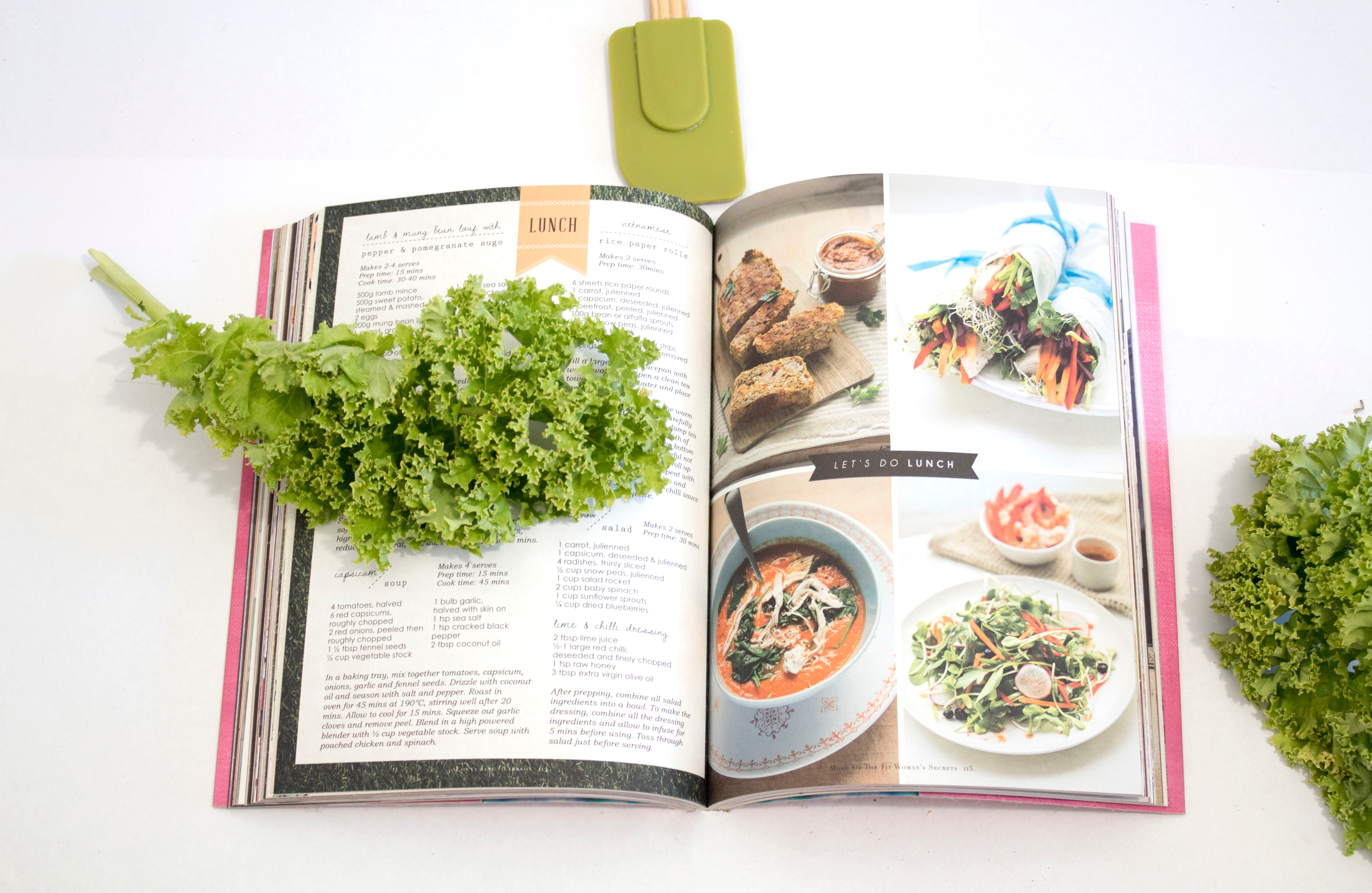 cookbook, kale, and spatula on table