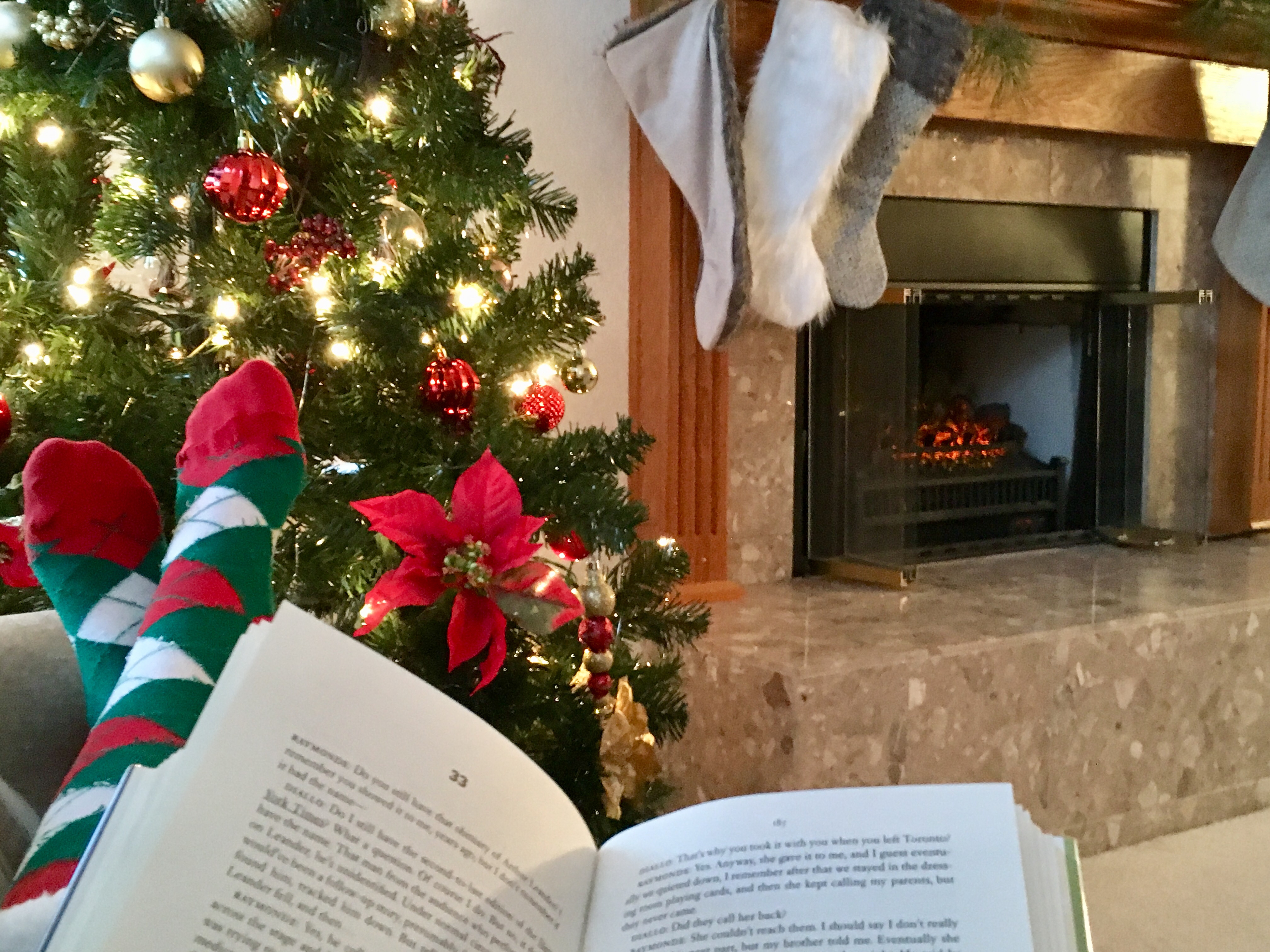 Open book in front of Christmas tree and fireplace