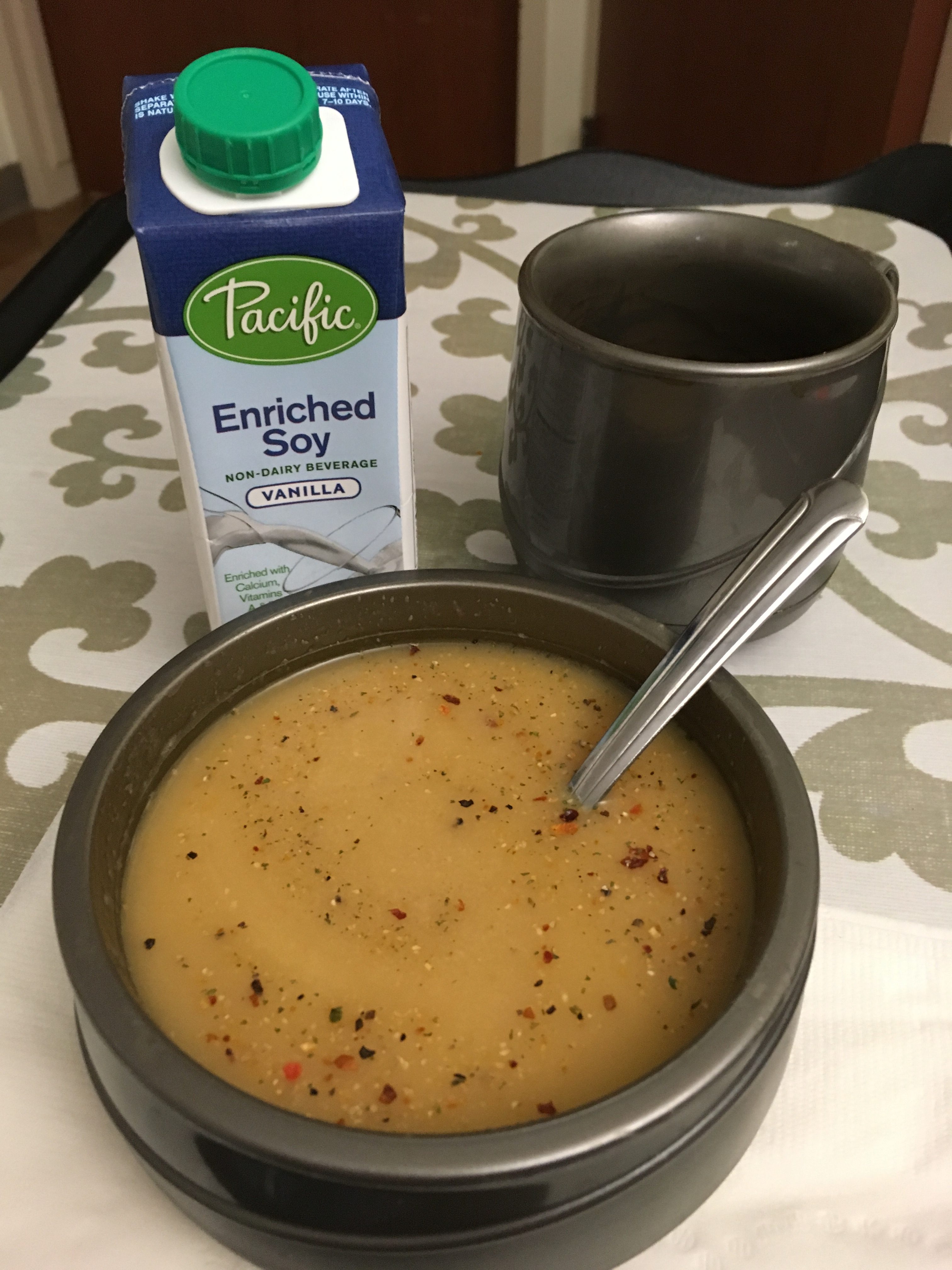 Soup, soy drink, and mug of coffee on table in hospital
