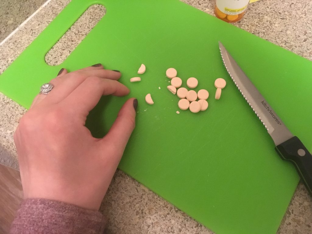 Jenna cutting pink prednisone pills in half to get the correct day's dosage