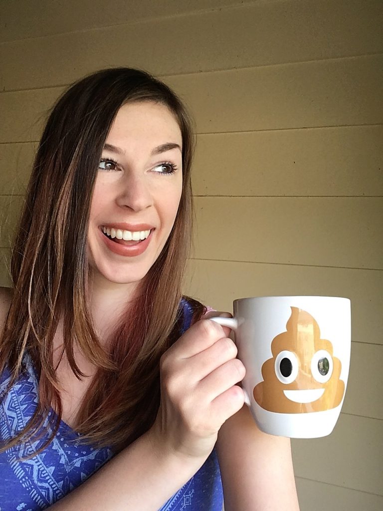 Jenna smiling and holding poop emoji mug