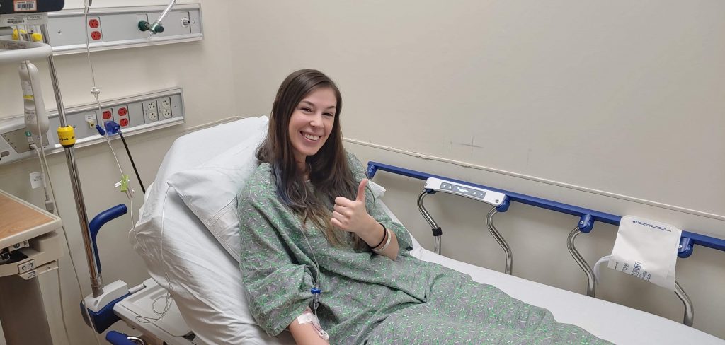 Jenna waiting for my liver biopsy in my hospital gown giving thumbs up